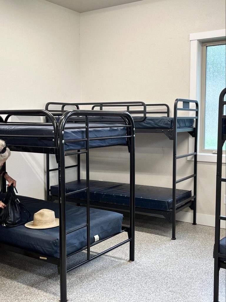 Metal-framed bunk bends within the cabins. Each bed is sized for one person.